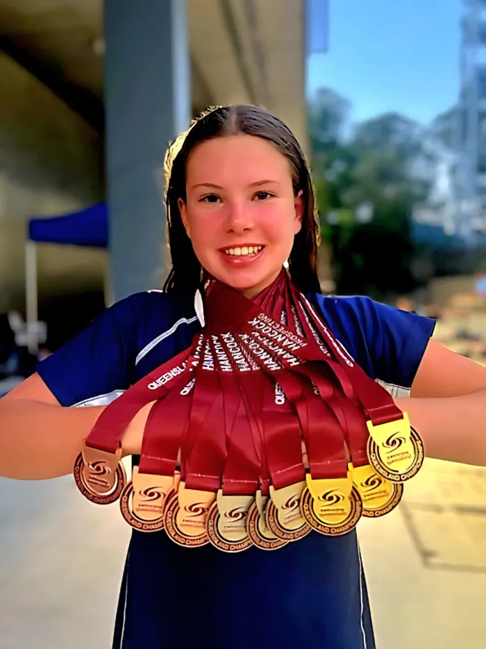 A swimmer fanning out a full carnival's worth of medals