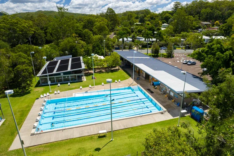 Eumundi Aquatic Centre from the air: the outdoor lane pool, clubhouse and car park, ringed by bushland